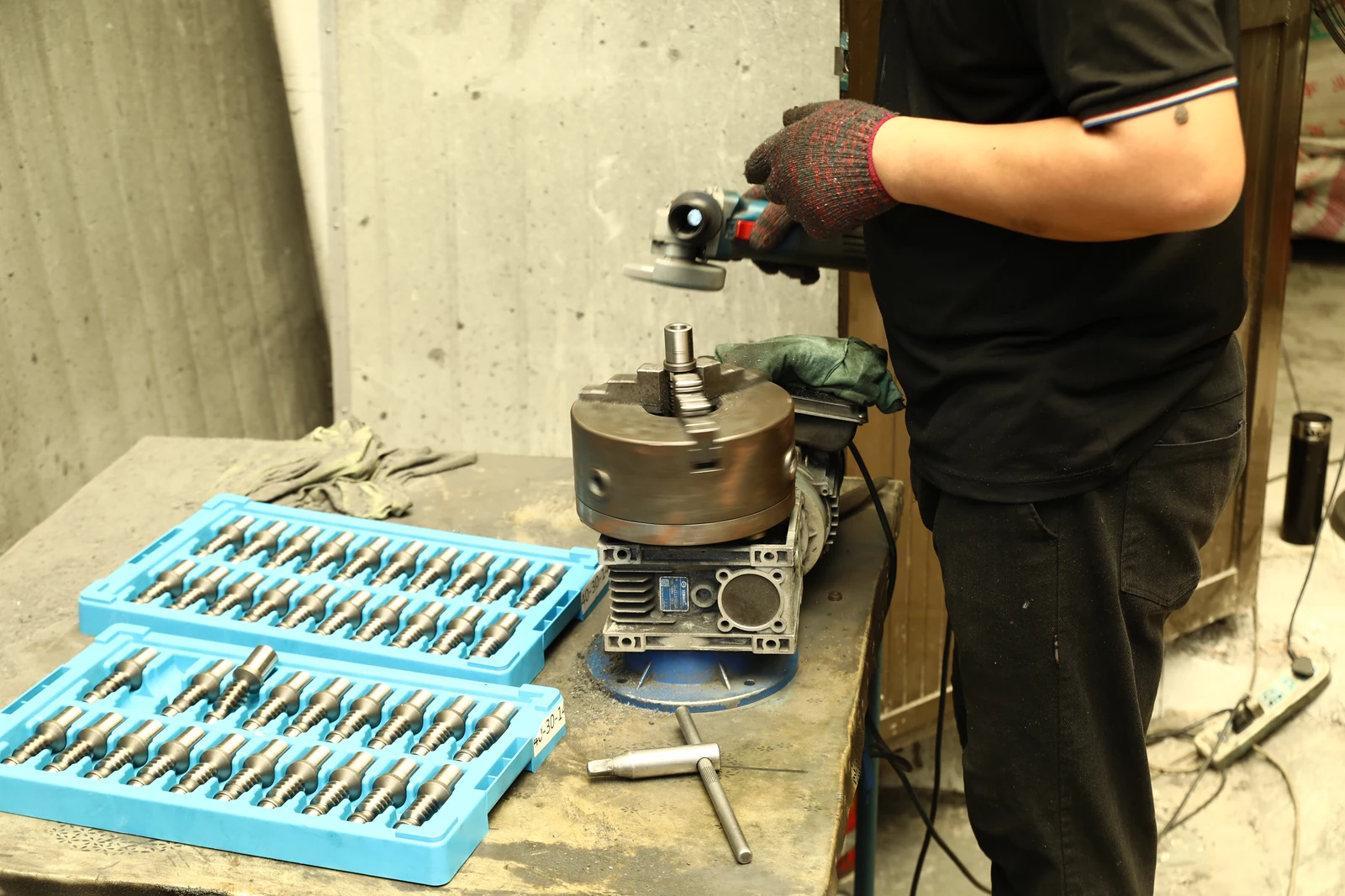 Worker finishing worm shafts in the SMK workshop